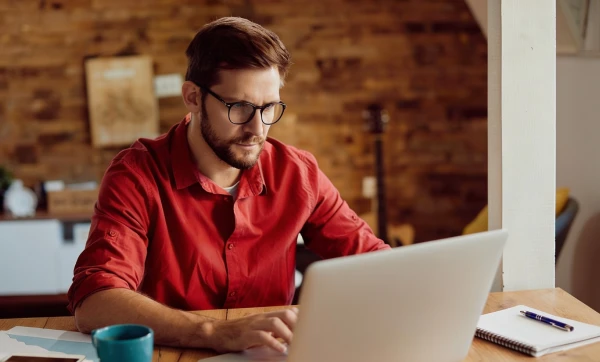 Cadastro de produtos na Reforma Tributária: erros que podem gerar multas ou autuações Empresário trabalhando em seu notebook em ambiente de escritório sobre Cadastro de produtos na Reforma Tributária: erros que podem gerar multas ou autuações.