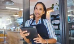 Faturamento acumulado do Simples: como acompanhar e não estourar o limite Profissional atendente de lanchonete trabalhando com tablet em mãos representando: Faturamento acumulado do Simples: como acompanhar e não estourar o limite