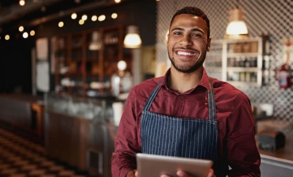 PDV para restaurante e bar: comanda, mesa e fechamento de conta Garçom de restaurante usando um tablet para trabalhar representando: PDV para restaurante e bar: comanda, mesa e fechamento de conta