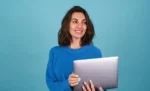 Melhor ERP para microempresa em 2026: comparativo completo Empreendedora feminina sorridente com um notebook em mãos representando: Melhor ERP para microempresa em 2026: comparativo completo