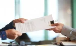 Contratos com fornecedores: cláusulas essenciais para se proteger de atrasos e prejuízos Papel segurado por duas pessoas em um escritório, representando: Veja quais cláusulas protegem sua empresa de atraso, defeito e calote de fornecedor, e como o GestãoClick organiza esse relacionamento na prática.