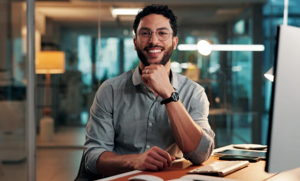 Parcelamento de débitos do Simples Nacional: como fazer e regularizar Homem sorridente em seu local de trabalho, representando: Parcelamento de débitos do Simples Nacional: como fazer e regularizar