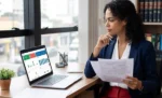 Advogada MEI: pode ser MEI, quais CNAE usar e como emitir nota fiscal Advogada em seu escritório, pensativa analisando uma planilha em seu notebook, representando: Advogada MEI: pode ser MEI, quais CNAE usar e como emitir nota fiscal
